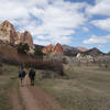 Two hikers on the Ute trail walking in the direction of Gray Rock (left) and the Gateway Rocks (center) at Garden of the Gods.