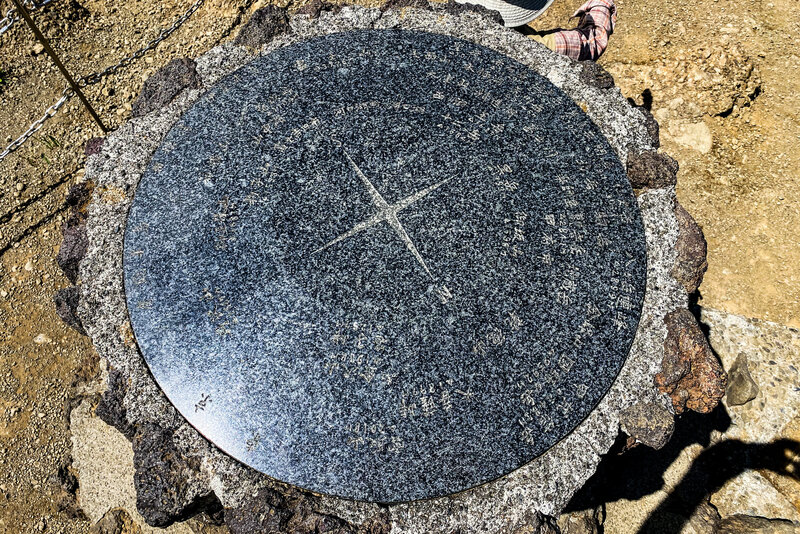 The compass pointing out the other mountains at the summit.