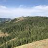 Looking west. Flat plateau with grass meadow in center of photo. Perfect camp spot