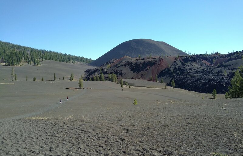 Cinder Cone with Fantastic Lava Beds at its base, are seen by hikers approaching the northern end of Rainbow Lake to Nobles Trail.