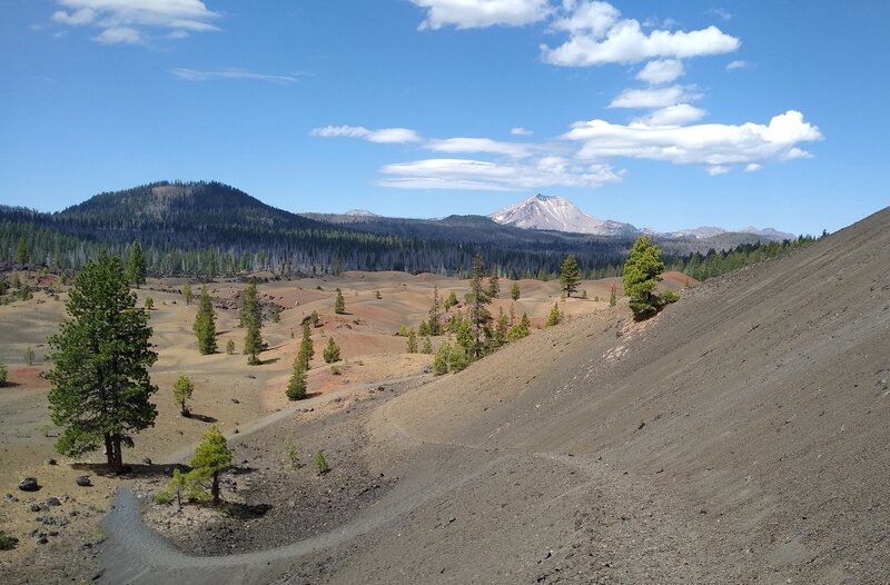 The trail goes down and winds through the Painted Dunes. On the horizon are nearby Fairfield Peak (left) and Lassen Peak center right.