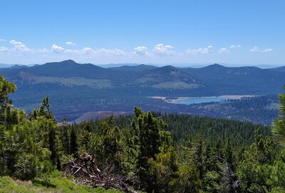 Looking southeast from the top of Prospect Peak, one can look into Cinder Cone below (center lower left). On the horizon are Red Cinder and Red CInder Cone (right center). Snag Lake (right) with Mt Hoffman nearby, behind it, are also seen.