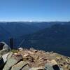 Distant mountains, including snow covered Mt. Rainier, 14,411 ft. (center right), Are seen looking southwest from the Poe Mountain summit - 6,015 ft.