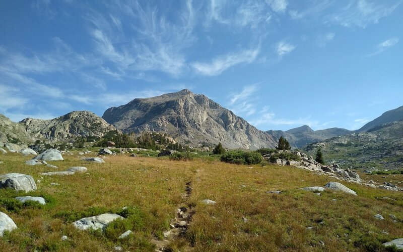 Pretty alpine meadows amid the high Peaks of the Wind Rivers near Lake 10542 on the way to Europe Pass. The peak looming ahead to the north, hides Europe Pass and the fifth/last lake on the way to Europe Pass.