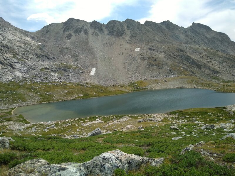 Climbing towards Europe Pass, the fourth lake on the way to the pass, Lake 10813, is set in the alpine meadows below.