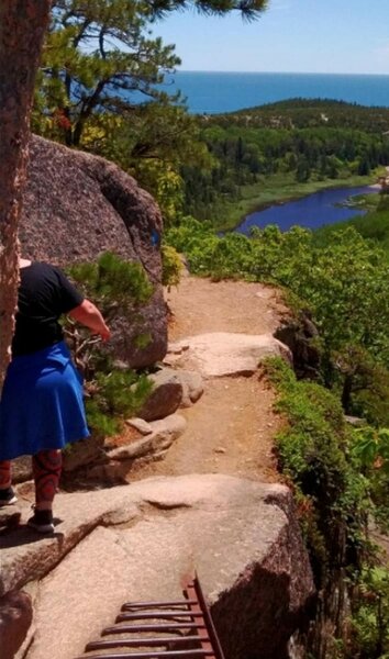 Narrow trail with a metal rebar crossing, 100 feet up with a view of the ocean. Sheer cliff, very slippery when wet.