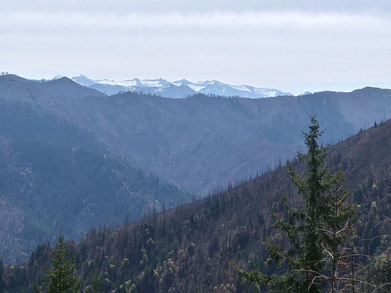 View of the distant high Trinity Alps, with Devils Backbone in the middle distance (May 2021).