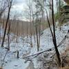 Snow covered valley from under rock shelf.