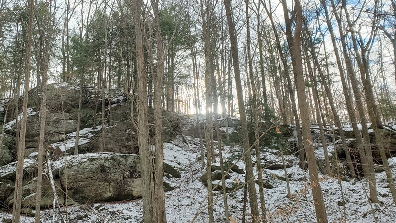 Sun peeking over snow-covered hillside