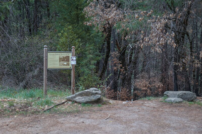 A sign marks the trailhead for the short walk to the creek and waterfall.