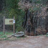 A sign marks the trailhead for the short walk to the creek and waterfall.