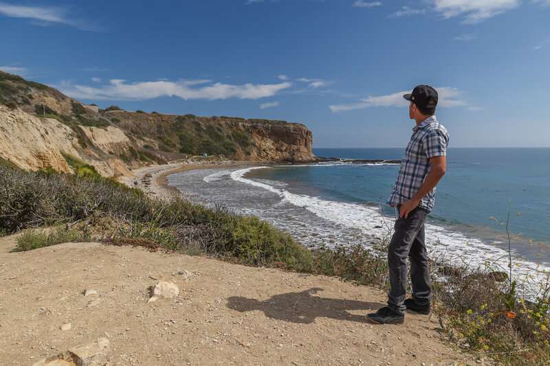 A trailside viewpoint of Sacred Cove Beach just before descending to it.