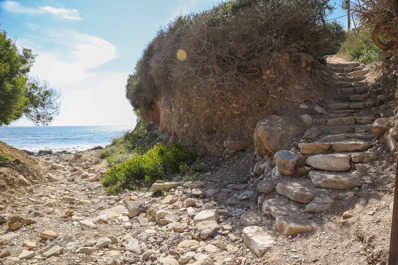 Stone steps along the trail descend into a small wash, which leads to Sacred Cove Beach.