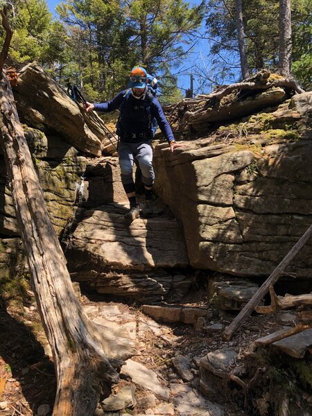 A hiker descends rocky trail.