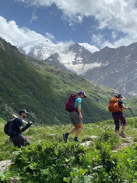 Crossing a pretty wildflower meadow below the Bionnassay Glacier.