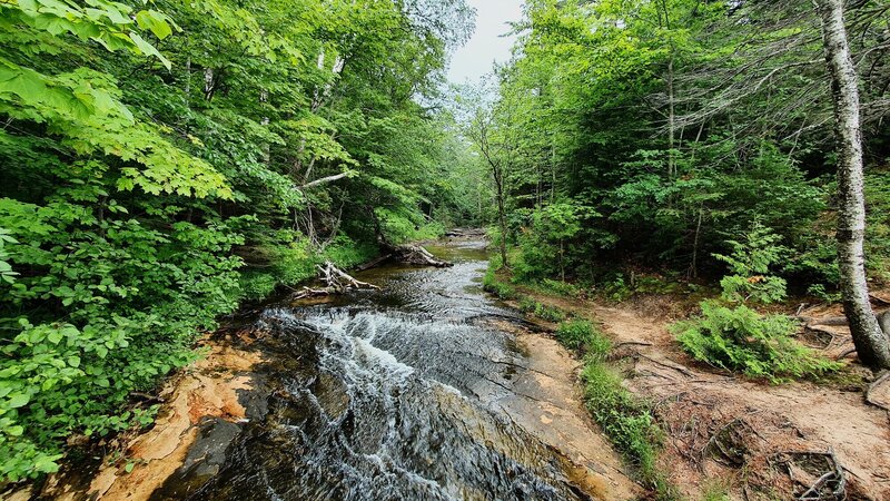 River flowing into Lake Superior (located behind photographer) on the coastline section of the trail near the Chapel Rock feature.