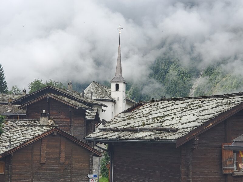 Cute old part of Blatten village on a foggy morning.