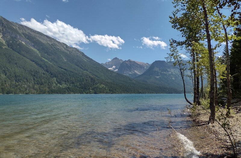 Rugged mountains across Upper Waterton Lake near the Canada/USA border, seen looking southeast from a small beach along Lakeshore Trail.