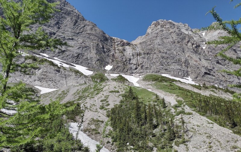 Snow melt from the Great Divide plunges down a distant waterfall to feed a creek in the forested valley (not visible) below.