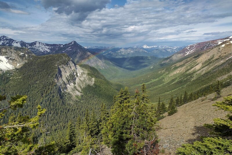 Just below the summit on the west side of Peak #5, a gorgeous valley stretches to the west-southwest, complete with snowy peaks into the distance forever. A brief sun shower hangs a rainbow over the valley if you look closely just upper left of center.