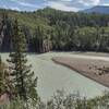 The silty Smoky River flowing right to left, entering the Sulphur Gates cliffs on the left to meet the Sulphur River (not seen) out of view to the left.