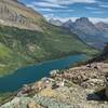 Gunsight Lake below at the base of Fusillade Mountain, 8.750 ft., (left). In the distance (center right) is Goint-to-the-Sun Mountain, 9.642 ft. Goats photo-bombing the picture. Looking northeast just below Gunsight Pass.