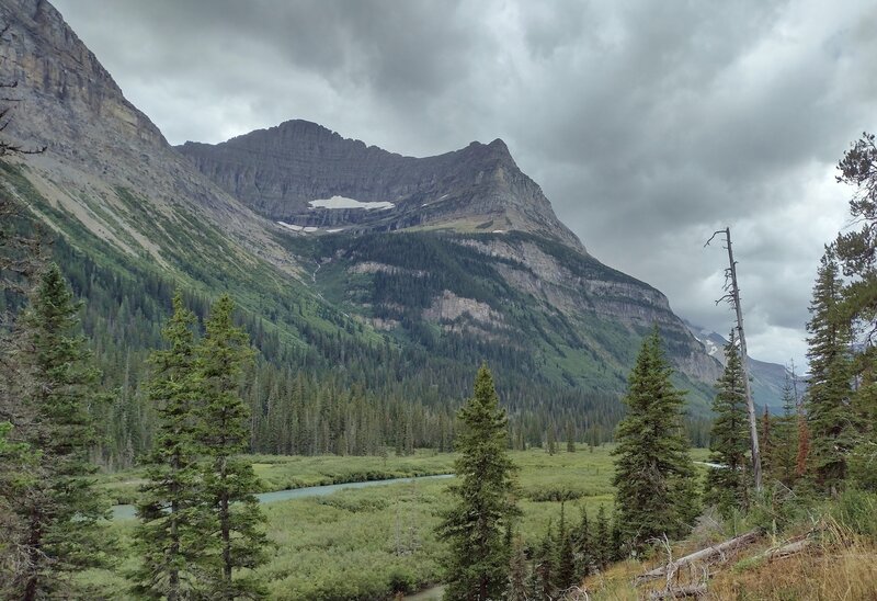 Turquoise St Mary River in pretty meadows, coming down from the mountains. North side of Citadel Mountain, 9,030 ft., center.