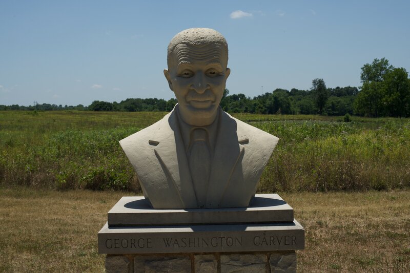 The George Washington Carver Bust by Audrey Corwin sits at the end of the Carver Trail in small plaza.