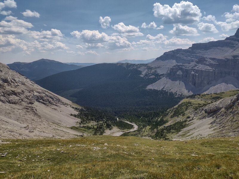 High on the east side of Tornado Saddle, South Hidden Creek headwaters are collected on the nearby slopes below. Rugged mountains stretch into the distance to the east.