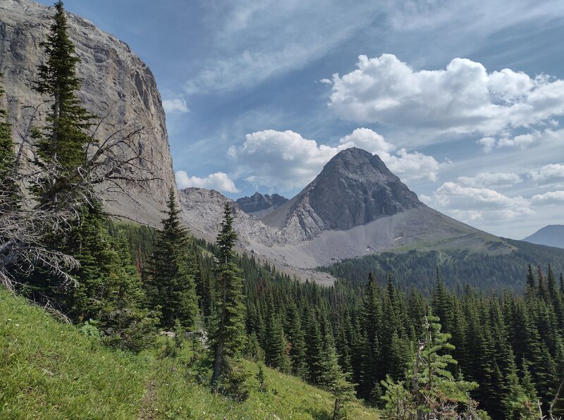 The high rocky ridge of Tornado Saddle has several peaks along it. Tornado Saddle is hidden behind the monolith on the left. Seen looking south from the steep, high meadows just below Tornado Mountain, between Tornado Saddle and Tornado Pass on the GDT.