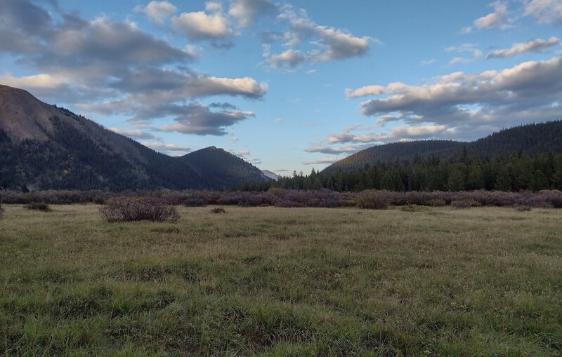 Evening light makes for a stunning view across the meadows to a valley through the mountains, to the east-northeast of Little Heaven trail camp.