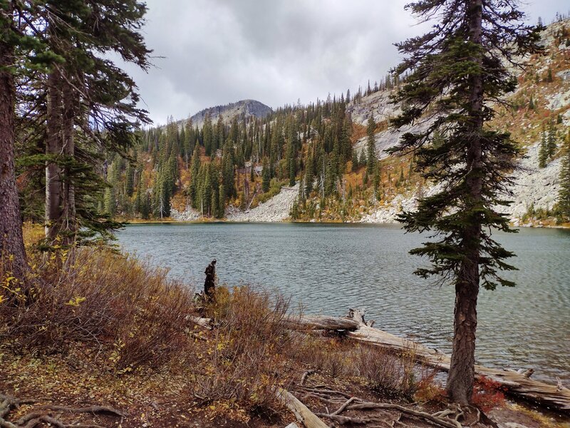 The second/middle lake in its steep, boulder covered bowl, seen from the forest trail along its south shoreline.