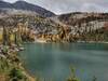 The gorgeous aquamarine color of the upper/third Roman Nose Lake, as sunlight strikes it. Also lighting up the golden larches on cliffs above the lake, As Roman Nose Peak, 7,260 ft., presides over all this beauty.