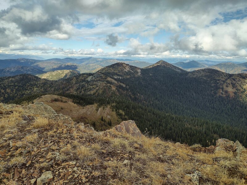 Pend Oreille Divide Trail continues north along the ridge by dome topped Mt. Willard (center), then around unnamed pointy peak (center right), followed by Mt. Purdy that's hidden behind Mt, Williard. Forested South Callahan Creek drainage below (right).