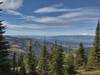 Lake Pend Oreille (center left) is in the distance below. Nearer, are fir forested foothills, dotted with bright yellow larches on a perfect October day. Seen looking southwest from high on Pend Oreille Divide Trail.