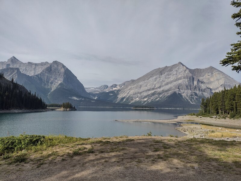 Upper Kananaskis Lake (foreground), Mount Sarrail, 10,400 ft. (left), and Mount Lyautey, 9,990 ft. (right). Fossil Falls (zoom in center left) in the distance. Seen looking southwest from the dam at the northeast corner of Upper Kananaskis Lake.