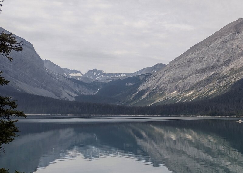 Looking across Upper Kananaskis Lake to the valley between Mount Sarrail and Mount Lyautey, peaks of the Great Divide are in the far distance, Mangin Glacier (center left), and Fossil Falls (center in the forested hills).