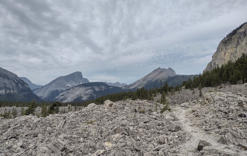 Cresting the Mt. Indefatigable rock slide, peaks along the Great Divide are seen to the west.