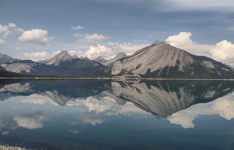 Mt. Indefatigable (right) and other rugged mountains, are mirrored in Upper Kananaskis Lake on a perfectly calm day.