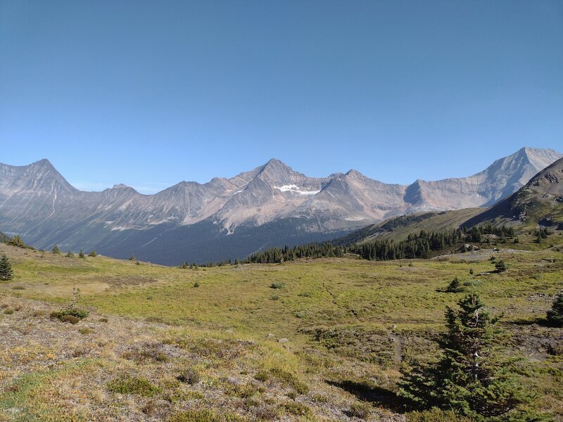 Cresting the pass between Jackpine Mountain and an unnamed peak to the northwest, views of the rugged mountains and glaciers to the northeast come into view, including Mt. Lucifer, 10,040 ft., (center).