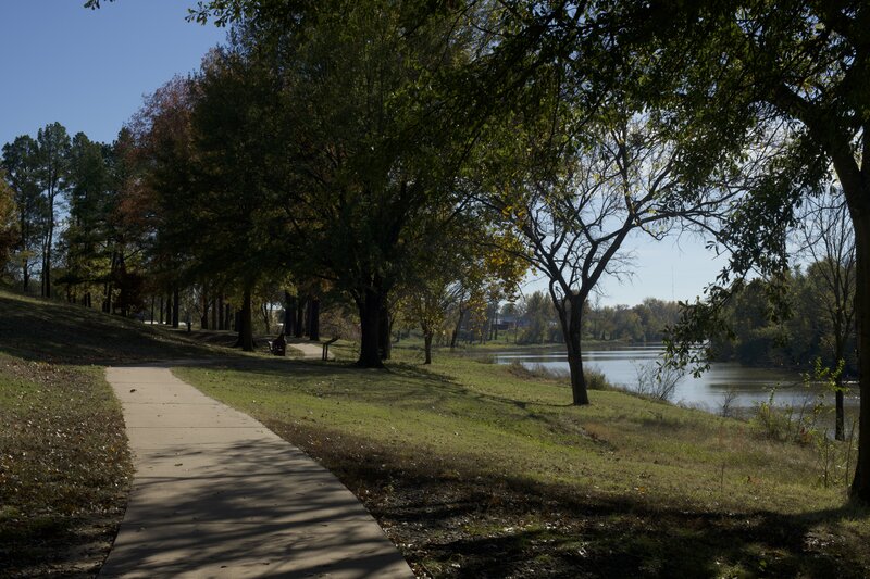 The trail meanders underneath the trees as it runs along the Arkansas River.