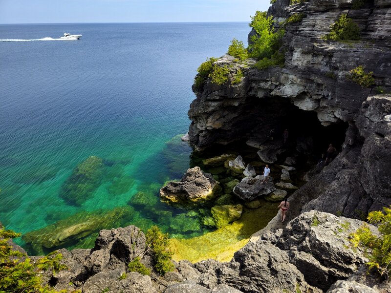 People swimming in the clear and colorful waters of the Grotto.
