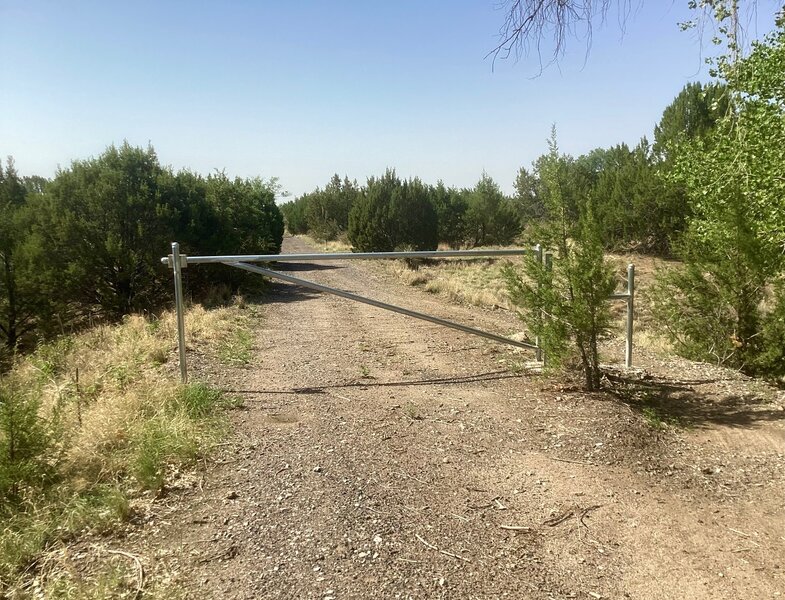 A gate with a pedestian pass-through along the old railroad grade trail.
