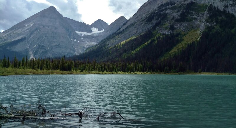 Upper Elk Lake. Glaciated peaks in the distance (left to right) - Mt. McCuiag (9,462 ft.), Mt. De Gaulle (9,686 ft.), Mt. Nivelle (10,683 ft.), and Mt. Casteinau (9.859 ft.). Nearby Mt. Elkan (9.056 ft.) upper right, rises from the lakeshore.