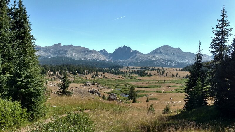 Dream Lake outlet creek valley ahead with the creek running through it. Peaks of the Continental Divide in the distance beyond this creek valley.