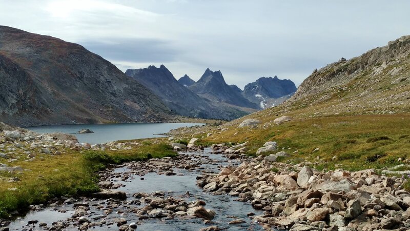 Snow melt flows into nearby Bewmark Lake in early August. Nylon Peak, 12.392 ft., (center) and Mount Bonneville, 12,585 ft., (right center) are in the distance to the south.