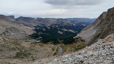 Looking down the east side of the Continental Divide from Photo Pass. The South Fork of Bull Lake Creek valley stretches into the distance. Milky Ridge, west/left, and Horse Mountain, east/right, rise from this valley.