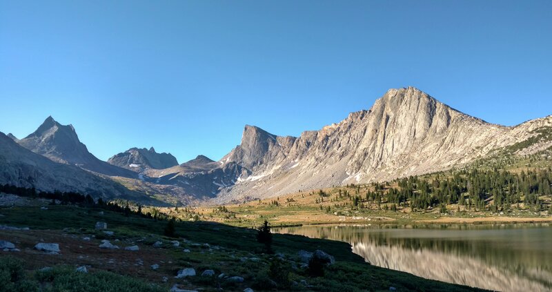 (left to right) Nylon Peak, Mount Bonneville, Pronghorn Peak, and Dragon Head Peak in the early morning sunlight, along with Middle Fork Lake and its surrounding meadows.