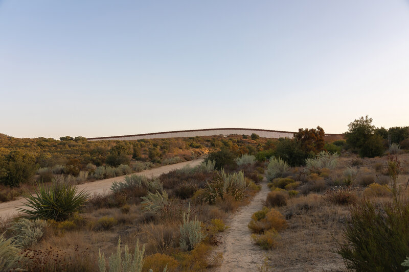 The border wall looming in the distance.