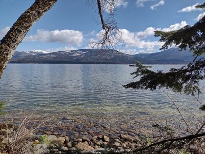 Looking east across Priest Lake, Cameis Prairie is the spawling hill on the other side of the lake. Mt Roothaan (left) is in the distance. Priest Lake's crystal clear waters lap against the rocky shoreline here. Not all is a beach along Beach Trail.